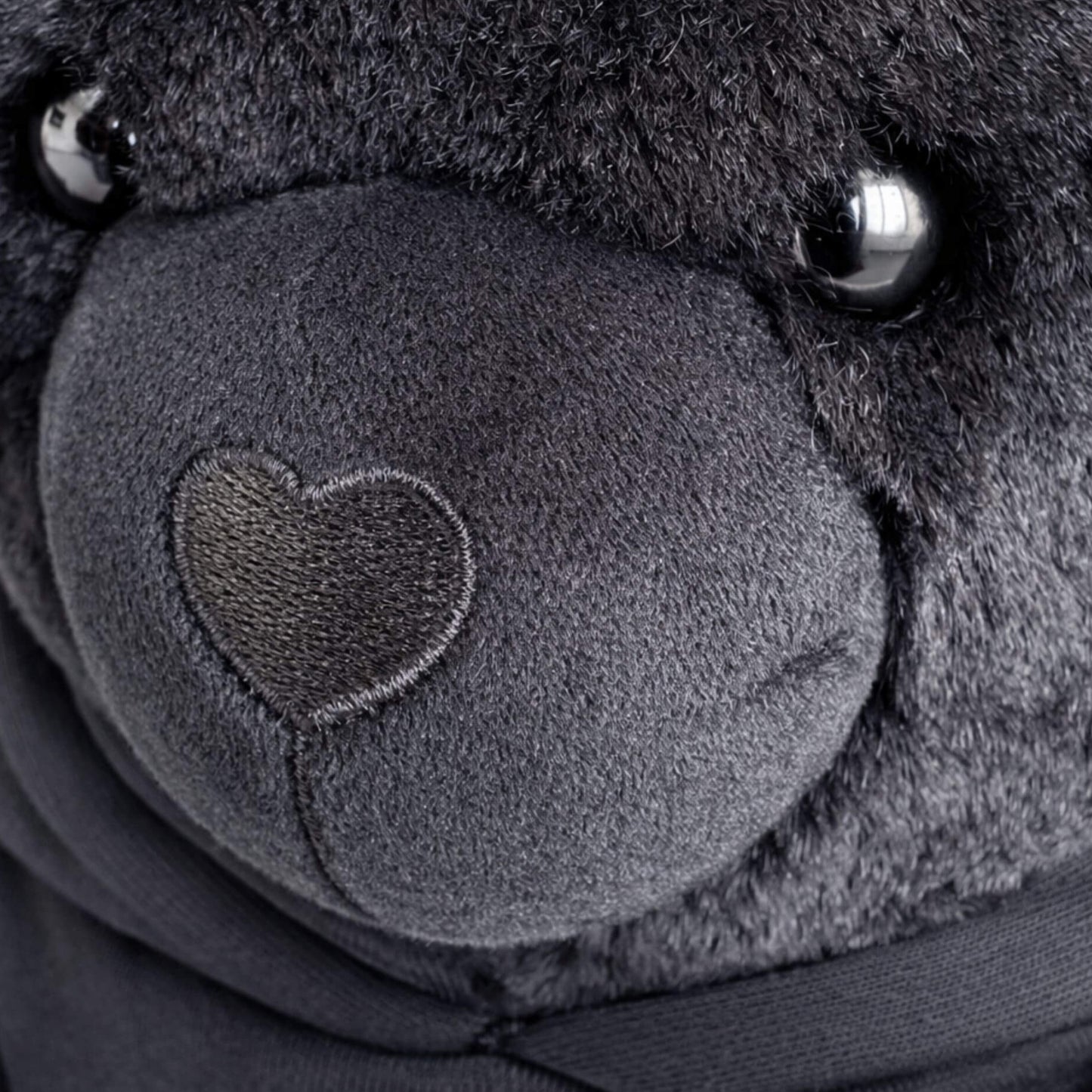 Detail van Mooqz plush bear met subtiele branding en premium stof